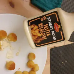 Kula frytek na talerzu, obok butelka sosu belgijskiego Street Food.