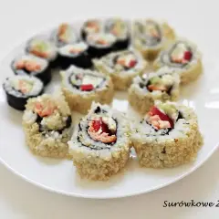 Talerz pełen pysznych roladek california sushi, z łososiem i awokado, posypanych sezamem.