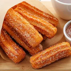 Churros co to? Złociste, posypane cukrem pałeczki smażone na głębokim tłuszczu, idealne do maczania w czekoladzie.