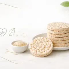 Stos ryżowych wafli i miseczka z ryżem. Czy wafle ryżowe są zdrowe? Ikony zdrowego stylu życia sugerują, że tak.