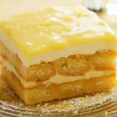 Pyszne tiramisu cytrynowe z warstwami biszkoptów i kremu, ozdobione cytrynową polewą.