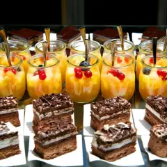 Szybkie mini deserki z galaretką i owocami, obok czekoladowe ciastka. Idealne na letnie przyjęcie.