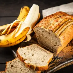 Wilgotne ciasto bananowe, pachnące i pyszne, obok dojrzałych bananów. Idealne na deser.