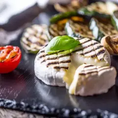 Pyszny camembert z grilla, z rumianymi paskami, podany z grillowanymi warzywami i pomidorkiem. Idealna przekąska na lato.