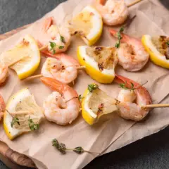 Szukasz pomysłu, jak zrobić krewetki? Oto pyszne krewetki na patyczkach z cytryną i ziołami, gotowe do grillowania lub pieczenia.