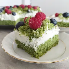 Zielony, puszysty biszkopt przełożony kremem z serkiem mascarpone, udekorowany malinami i borówkami. To ciasto leśny mech na dużą blachę, które zachwyca smakiem.
