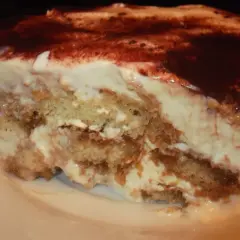 Pyszny kawałek tiramisu bez alkoholu, z warstwami biszkoptów i kremu, posypany kakao.