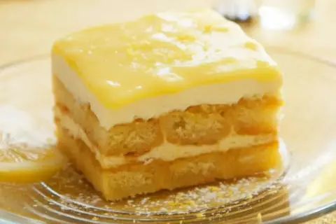 Pyszne tiramisu cytrynowe z warstwami biszkoptów i kremu, ozdobione cytrynową polewą.