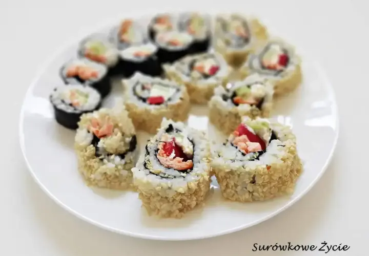 Talerz pełen pysznych roladek california sushi, z łososiem i awokado, posypanych sezamem.