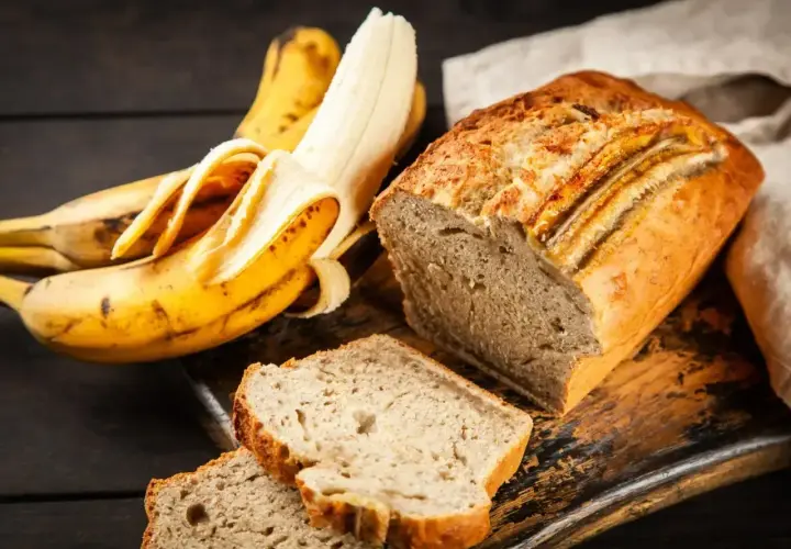 Wilgotne ciasto bananowe, pachnące i pyszne, obok dojrzałych bananów. Idealne na deser.