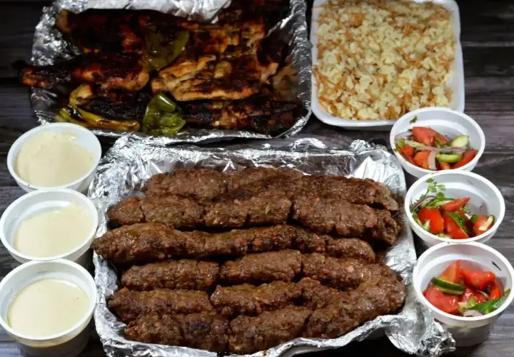 Pyszny kofta kebab z grillowanym kurczakiem, ryżem i sałatkami. Idealny posiłek na wynos.