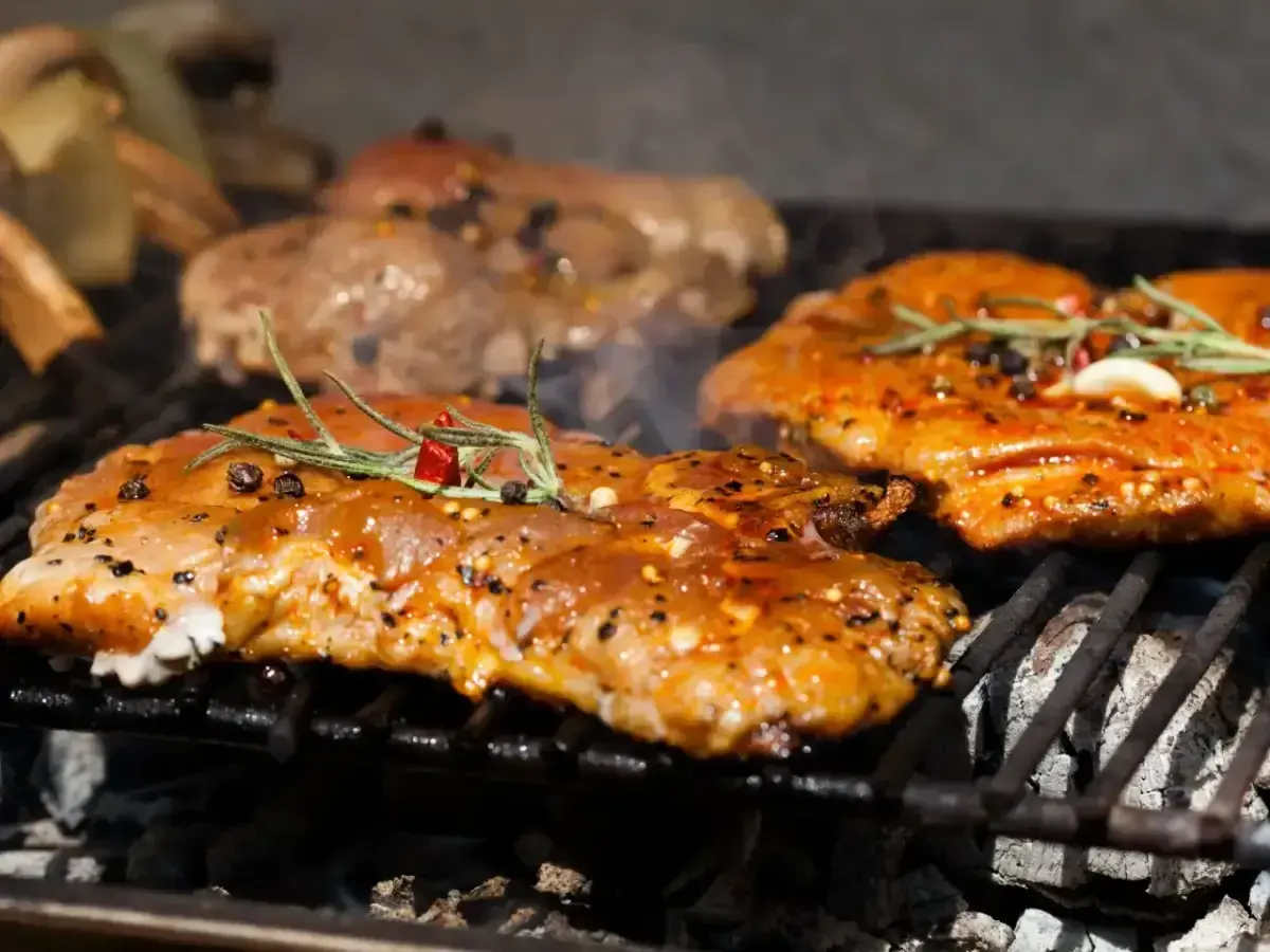 Soczysta karkówka z grilla, doprawiona ziołami i pieprzem, dymi na ruszcie. Idealna na letnie popołudnie.