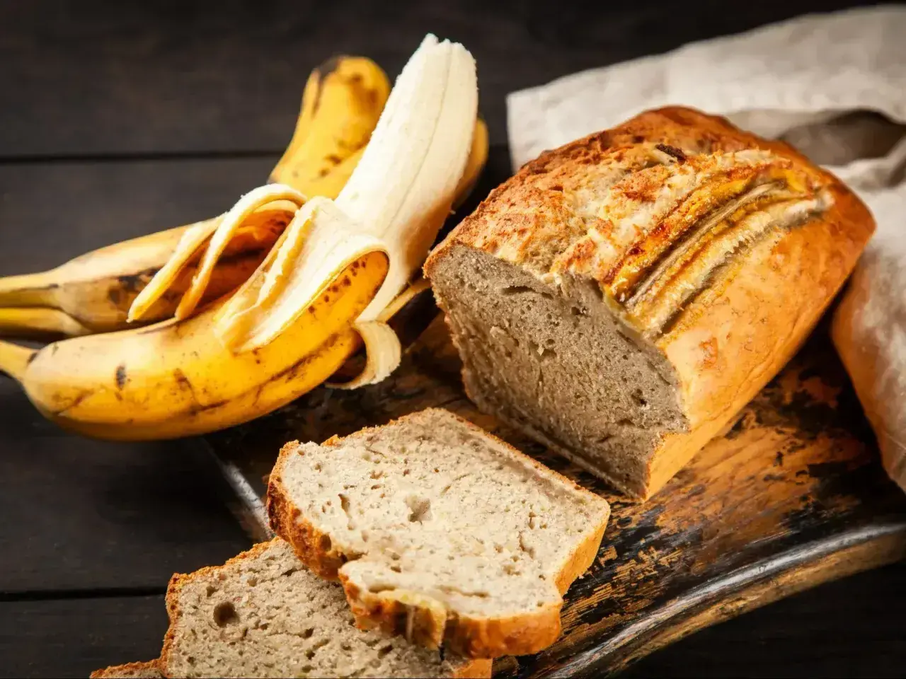 Wilgotne ciasto bananowe, pachnące i pyszne, obok dojrzałych bananów. Idealne na deser.