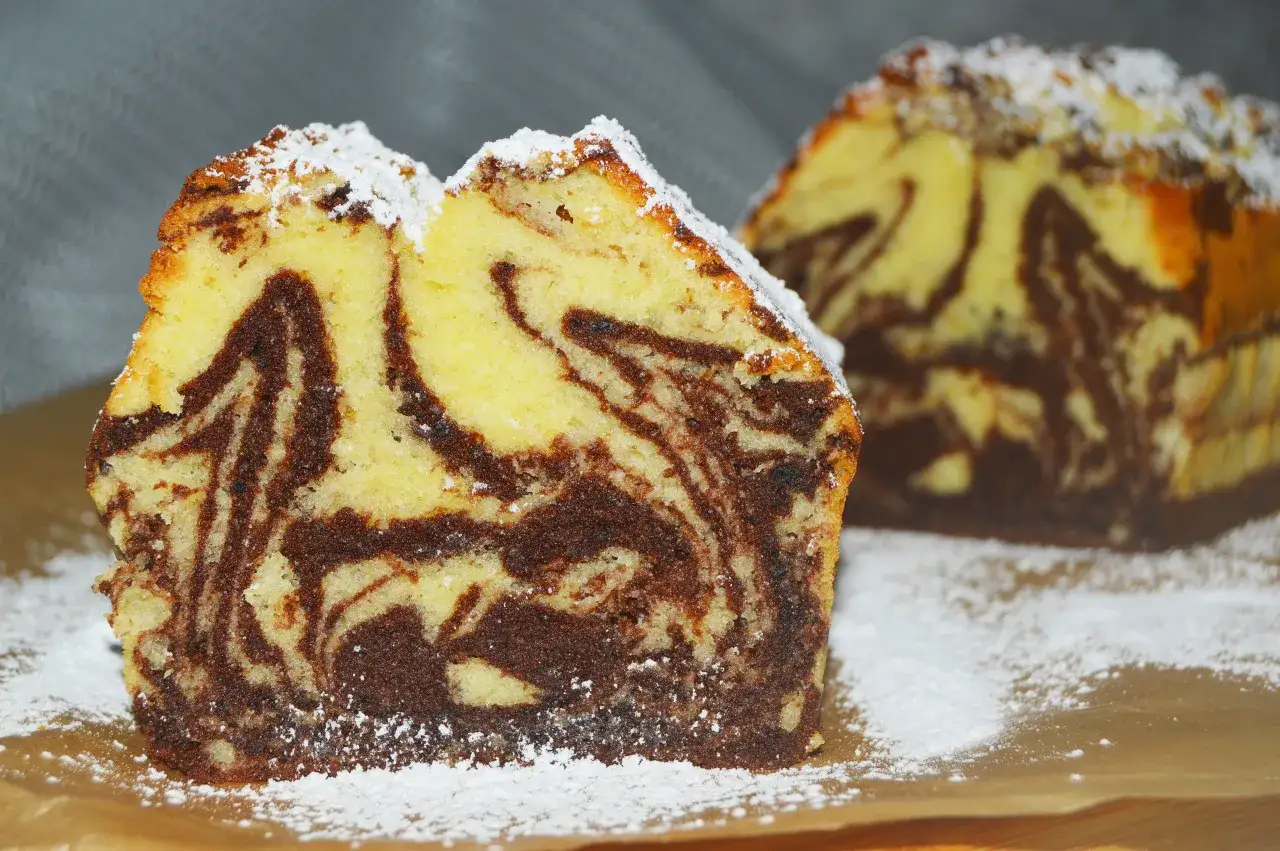 Wilgotna babka marmurkowa na oleju, oprószona cukrem pudrem. Wspaniały deser, który zachwyca wyglądem i smakiem.